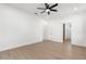 Spacious bedroom with wood-look floors, ceiling fan, and white doors at 14042 Amero Ln, Spring Hill, FL 34609