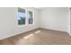 Bright bedroom features wood-look floors, two windows, and a walk-in closet at 14042 Amero Ln, Spring Hill, FL 34609