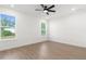 Bedroom featuring two large windows, wood-look floors, and a ceiling fan at 14042 Amero Ln, Spring Hill, FL 34609