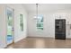 Bright dining area with wood-look floors, white walls, large windows, and a modern light fixture at 14042 Amero Ln, Spring Hill, FL 34609