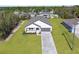 An aerial shot showcasing the inviting front exterior, green lawns, concrete driveway, and attached garage at 14042 Amero Ln, Spring Hill, FL 34609