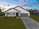 Exterior showcasing the home's tidy front lawn, paved driveway, and seamless attached garage in an attractive exterior shot at 14042 Amero Ln, Spring Hill, FL 34609