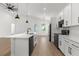 Modern kitchen featuring white cabinets, stainless steel appliances, an island, and wood-look floors at 14042 Amero Ln, Spring Hill, FL 34609