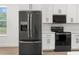 Modern kitchen with black stainless steel appliances, white cabinetry, and sleek countertops at 14042 Amero Ln, Spring Hill, FL 34609