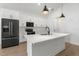 Modern kitchen features white cabinets, stainless steel appliances, a large island, and sleek black accents at 14042 Amero Ln, Spring Hill, FL 34609