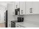 Bright, clean kitchen with white cabinets, black stainless appliances, and a minimalist design at 14042 Amero Ln, Spring Hill, FL 34609