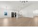Open floorplan featuring wood-look floors, white walls, and a kitchen with stainless steel appliances at 14042 Amero Ln, Spring Hill, FL 34609