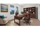 Well-lit home office with a built-in bookcase, comfortable seating, and views of the outdoors at 14042 Amero Ln, Spring Hill, FL 34609