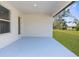 Covered patio with a blue floor, white walls, and a view of the lush backyard at 14042 Amero Ln, Spring Hill, FL 34609