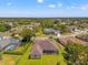 Aerial view showcases a backyard with a screened lanai and houses in a neighborhood surrounded by trees at 14163 Andrew Scott Rd, Spring Hill, FL 34609
