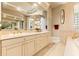 Bright bathroom with a long vanity, framed mirrors and a decorative corner tub at 14163 Andrew Scott Rd, Spring Hill, FL 34609