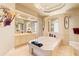 Luxurious bathroom featuring a large soaking tub, neutral tiles, and a decorative asian fan at 14163 Andrew Scott Rd, Spring Hill, FL 34609