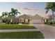 Inviting home with brick-accented facade, paver driveway, and lush landscaping at 14163 Andrew Scott Rd, Spring Hill, FL 34609