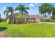 Lovely home featuring a well-manicured lawn, mature palms, and lush landscaping at 14163 Andrew Scott Rd, Spring Hill, FL 34609