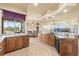 Spacious kitchen features wood cabinetry, tile floors, granite counters, and a view of the backyard at 14163 Andrew Scott Rd, Spring Hill, FL 34609
