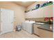 Convenient laundry room with a washer, dryer, storage cabinets, sink, and countertop space at 14163 Andrew Scott Rd, Spring Hill, FL 34609