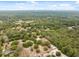 A serene aerial view showcasing a home amid lush greenery and a vast expanse of natural woodland at 14740 Loma Ave, Spring Hill, FL 34610