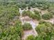 Aerial view showing the house, surrounded by trees, and a pool in the distance at 14740 Loma Ave, Spring Hill, FL 34610