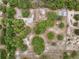 A captivating aerial view of the property shows a pool, greenhouses and surrounding trees and sandy landscape at 14740 Loma Ave, Spring Hill, FL 34610