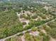 Aerial view of a home in a wooded area with a swimming pool at 14740 Loma Ave, Spring Hill, FL 34610