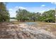 Expansive backyard featuring an above-ground pool, greenhouse, and mature trees, perfect for recreation and relaxation at 14740 Loma Ave, Spring Hill, FL 34610