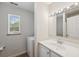 Bright bathroom featuring a window, vanity with sink, and a door to the shower at 14740 Loma Ave, Spring Hill, FL 34610