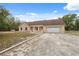 Welcoming single-story home boasts a neutral facade, arched windows, attached garage, and inviting front porch at 14740 Loma Ave, Spring Hill, FL 34610