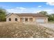 Attractive single-story home featuring a neutral facade, arched windows, attached garage, and inviting front porch at 14740 Loma Ave, Spring Hill, FL 34610