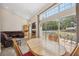 Bright living room featuring a cozy fireplace, large windows with backyard pool view, and an adjacent dining area at 14740 Loma Ave, Spring Hill, FL 34610