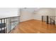 Upstairs loft showcasing hardwood floors, natural lighting, and a modern railing system at 14740 Loma Ave, Spring Hill, FL 34610