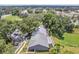 An aerial view shows the home with a fenced yard and mature landscaping in a quiet, tree-filled neighborhood at 1486 Loman Ct, Palm Harbor, FL 34683