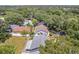 An aerial view shows this home with a fenced-in yard surrounded by mature trees in a quiet neighborhood at 1486 Loman Ct, Palm Harbor, FL 34683