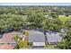 An aerial view shows a fenced-in yard with mature trees on a property located in a quiet neighborhood at 1486 Loman Ct, Palm Harbor, FL 34683