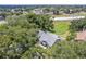 An aerial view of this home shows mature trees, fenced-in yard, and is located in a suburban neighborhood at 1486 Loman Ct, Palm Harbor, FL 34683