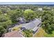 An aerial view shows the home with mature landscaping, fenced yard and is located in a quiet, tree-filled neighborhood at 1486 Loman Ct, Palm Harbor, FL 34683