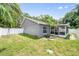 A view of a large backyard and screened in patio and white fence at 1486 Loman Ct, Palm Harbor, FL 34683