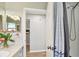 Bright bathroom features a shower with gray curtain and opens to reveal a glimpse of the kitchen at 1486 Loman Ct, Palm Harbor, FL 34683