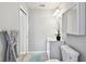 Neutral bathroom with white vanity, round mirror, and tiled floor at 1486 Loman Ct, Palm Harbor, FL 34683