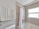 Bathroom featuring a built-in shower-tub combo, complemented by a mirrored medicine cabinet and tile surround at 1486 Loman Ct, Palm Harbor, FL 34683
