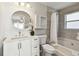 Bathroom features white vanity, medicine cabinet, round mirror, and shower-tub combo with curtain at 1486 Loman Ct, Palm Harbor, FL 34683
