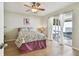 Cozy bedroom with floral bedding, wood floor, and sliding glass doors to the screened lanai at 1486 Loman Ct, Palm Harbor, FL 34683
