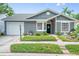 Charming one-story home with gray siding, manicured landscaping, and a cozy front porch at 1486 Loman Ct, Palm Harbor, FL 34683