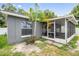 Exterior view of the home featuring a screened-in patio and well-maintained landscaping at 1486 Loman Ct, Palm Harbor, FL 34683