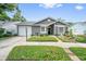 Well-maintained one-story home with attached garage, manicured lawn and mature landscaping at 1486 Loman Ct, Palm Harbor, FL 34683