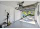 View of a functional garage space with storage, an automatic door opener, and access to natural light at 1486 Loman Ct, Palm Harbor, FL 34683