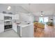 Modern white kitchen open to living room featuring updated appliances, marble countertops, and tile backsplash providing great flow at 1486 Loman Ct, Palm Harbor, FL 34683