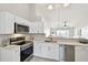 Well-lit kitchen showcasing white cabinets, quartz countertops, and stainless steel appliances at 1486 Loman Ct, Palm Harbor, FL 34683