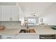 Modern kitchen with white cabinets, stainless steel sink, and view to a naturally lit sitting room at 1486 Loman Ct, Palm Harbor, FL 34683