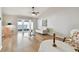 A bright living room features wood flooring, light walls, patio access, and a ceiling fan at 1486 Loman Ct, Palm Harbor, FL 34683