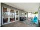 Covered patio features a sliding glass door, comfortable seating, and an indoor-outdoor living space at 1486 Loman Ct, Palm Harbor, FL 34683